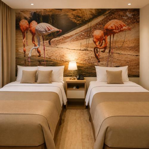 two beds in a room with a mural of flamingos at Hotel Soul Mate Inn in Lima