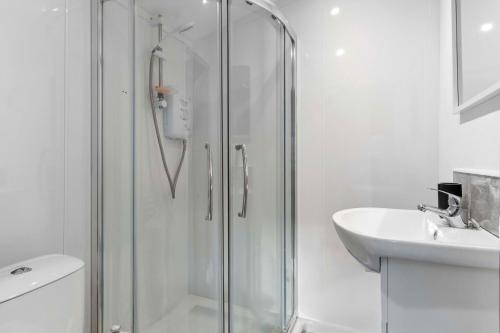 a white bathroom with a shower and a sink at Countryside Studio with Private Sauna in Sacomb