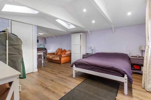 a bedroom with a bed and a couch at Countryside Studio with Private Sauna in Sacomb