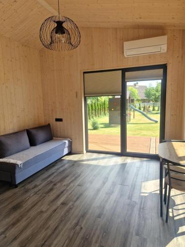 a room with a couch and a large glass door at Jaunmāriņi in Liepāja