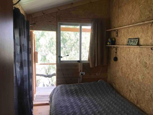a bedroom with a bed and a large window at Shepherds Cabin in Kadita - בקתת רועה בקדיתא in Kadita