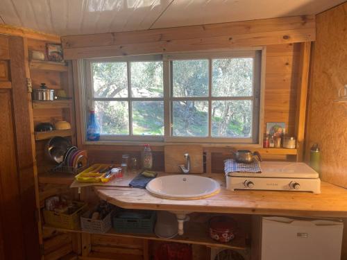 a kitchen counter with a sink and a window at Shepherds Cabin in Kadita - בקתת רועה בקדיתא in Kadita