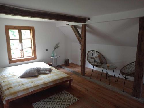 a bedroom with a bed and a window and a chair at Good Chata Leśna Polana in Dobry Las