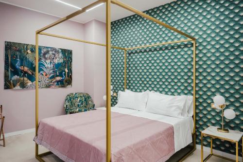 a bedroom with a canopy bed and a blue wall at Le Pepite Collection in Giardini Naxos
