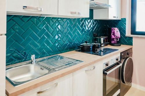 a kitchen with a sink and a stove at Le Pepite Collection in Giardini Naxos