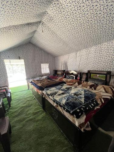 a bedroom with a bed in a room with a ceiling at Chaukhamba Camp Stay in Chopta