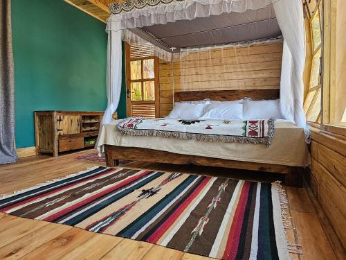 a bedroom with a canopy bed and a rug at Hidden Valley Backpackers in Iringa
