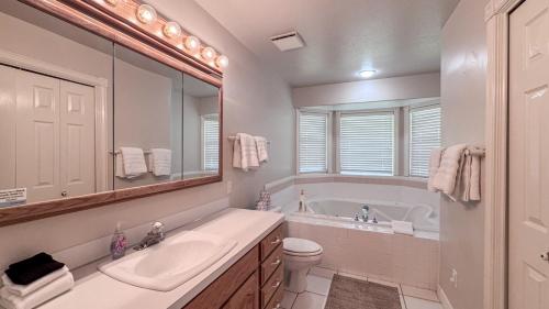 a bathroom with a tub and a sink and a toilet at The Beach House I in Garden City
