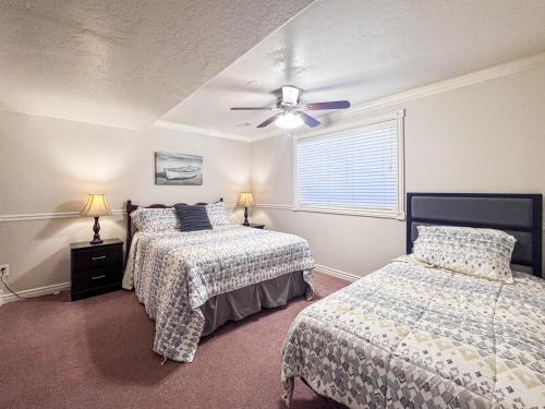 a bedroom with two beds and a ceiling fan at The Beach House I in Garden City