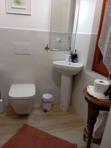 a white bathroom with a toilet and a sink at Elico Di Sicilia home B in Sambuca di Sicilia