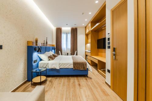 a hotel room with a blue bed and a table at Arbo Boutique Hotel in Durrës