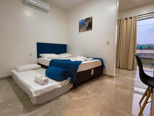 two beds in a room with a window at Pousada Mar de Luna in Penha