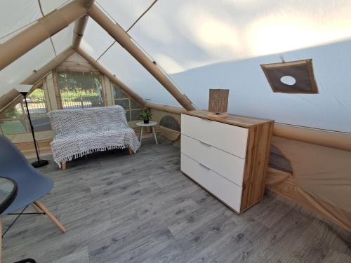 a room with a dresser and a chair in a tent at Namiot glampingowy u Kasi in Pojezierze