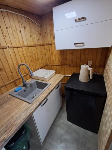 a small kitchen with a sink and a refrigerator at Namiot glampingowy u Kasi in Pojezierze