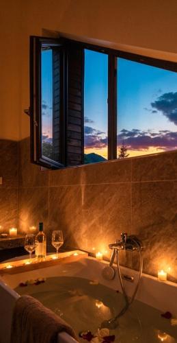 a bathroom with a bath tub with a window at Artizan Chalet in Topliţa