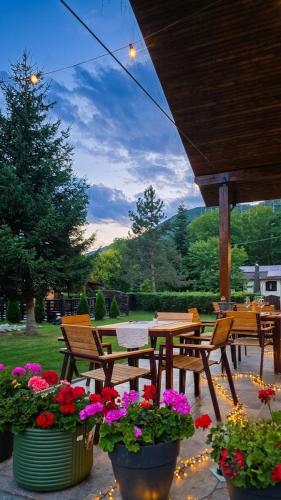 a patio with a table and chairs and flowers at Artizan Chalet in Topliţa