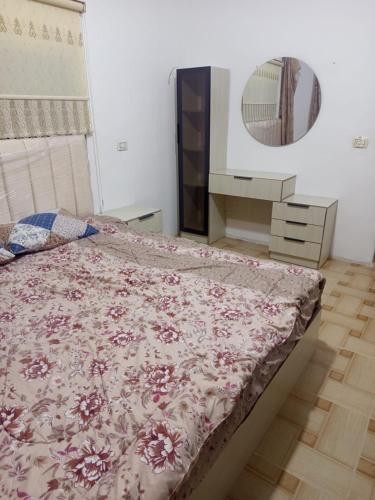 a bedroom with a bed and a mirror at بيت مفروش للايجار-عجلون-اشتفينا in Ajloun