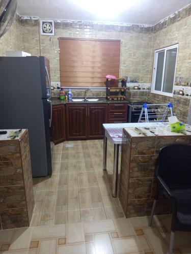 a kitchen with a refrigerator and a table at بيت مفروش للايجار-عجلون-اشتفينا in Ajloun