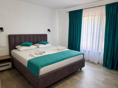 a bedroom with a large bed with green and white at Denisa & Rares in Tăşnad