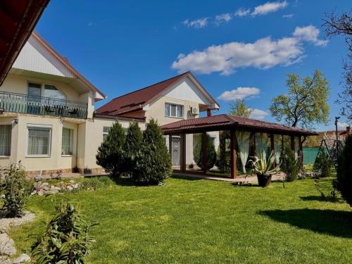 a house with a gazebo in a yard at Denisa & Rares in Tăşnad