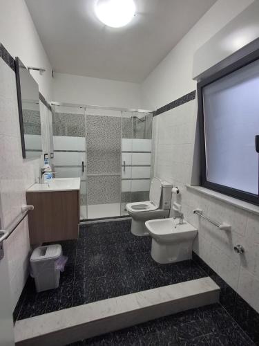 a bathroom with two toilets and a projection screen at pomelia holiday house in Riposto