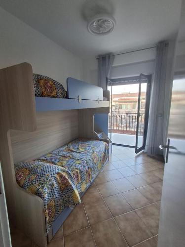 a bedroom with two bunk beds and a balcony at pomelia holiday house in Riposto
