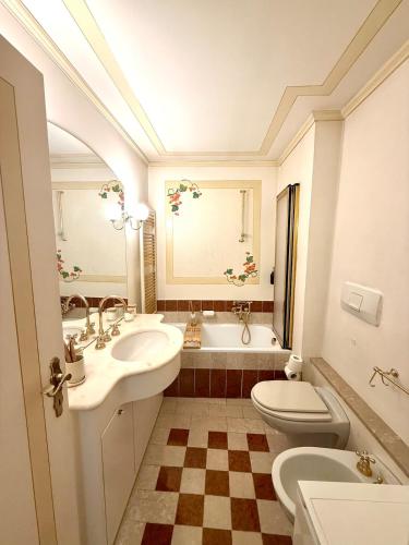 a bathroom with a sink and a toilet and a tub at Maison Moena Dolomites in Moena