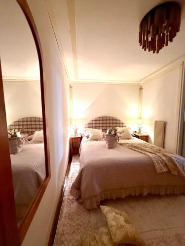 a bedroom with two beds and a mirror at Maison Moena Dolomites in Moena