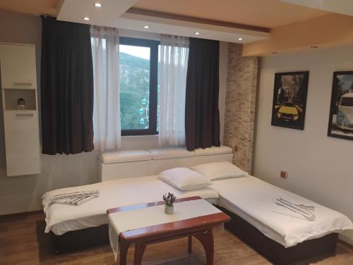 a hotel room with two beds and a window at STADIUM 2 Apartments Sandanski in Sandanski