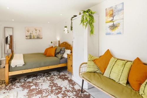 a living room with a bed and a couch at Garden Studio En-Suite in Egham
