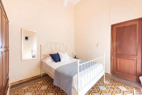 a bedroom with a white bed and a wooden door at Casa Donderis in Santo Domingo