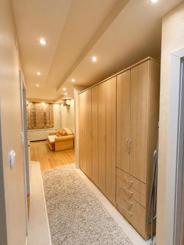 a large closet with wooden cabinets in a room at Sunset Apartman Obrenovac,Centar in Obrenovac