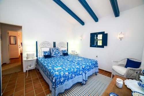 a bedroom with a blue bed and a chair at Descansadero in Bolonia