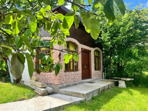 a small brick house with a door and stairs at Marisi Cottage - კოტეჯი მარისი in Ambrolauri