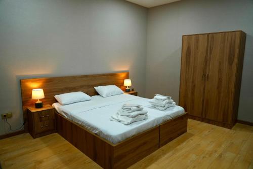 a bedroom with a bed with towels on it at Hotel Kvarlis Mtebi in Kvareli