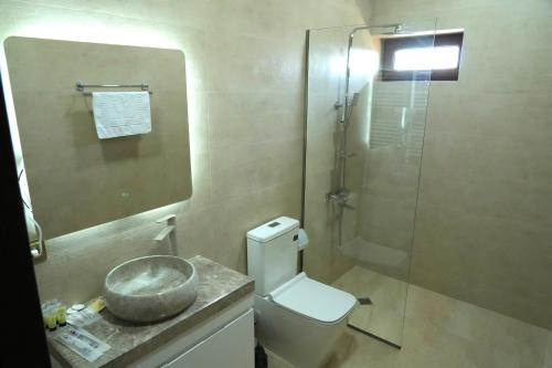 a bathroom with a toilet and a glass shower at Hotel Kvarlis Mtebi in Kvareli