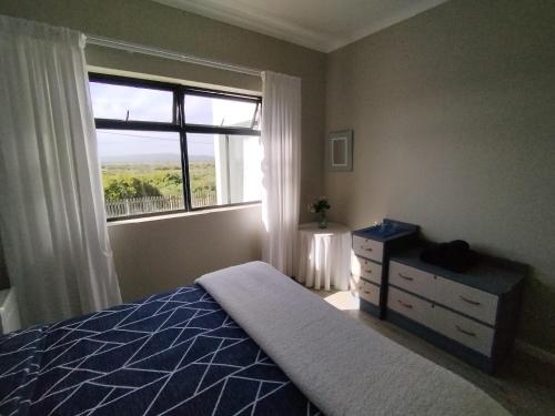 a bedroom with a bed and a window at Intimi2 in Yzerfontein