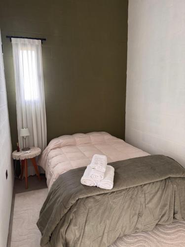 a bedroom with two towels sitting on a bed at Entre Paz y Enfoque in Luján