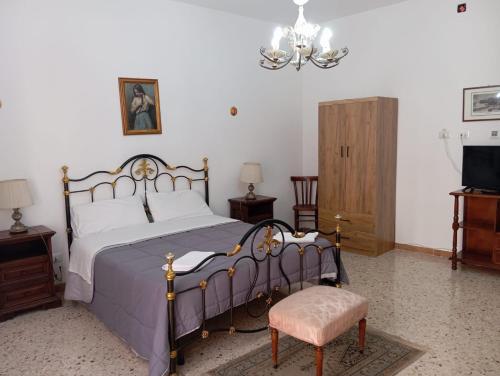 a bedroom with a bed and a chair and a television at Elico Di Sicilia home B in Sambuca di Sicilia