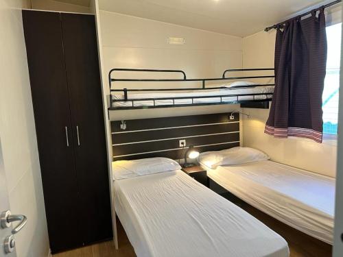 a room with two bunk beds and a window at Sottomarina Bungalows Spiaggia in Sottomarina