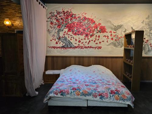 a bedroom with a tree mural on the wall at kyoto b&b in Ostend