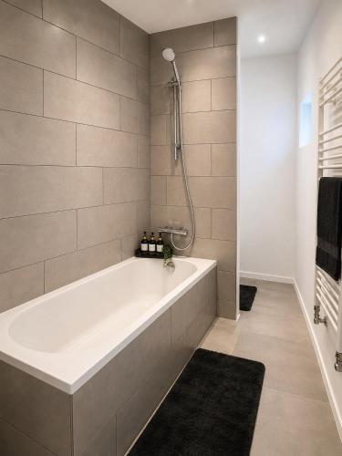 a white bath tub in a bathroom with a black rug at Maison Traversière in Long de Bout
