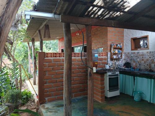 a kitchen with a brick wall and a stove at Vila Chapada Alta - Chapada dos Veadeiros in Alto Paraíso de Goiás
