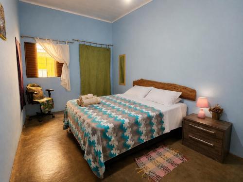 a bedroom with a bed and a table and a chair at Vila Chapada Alta - Chapada dos Veadeiros in Alto Paraíso de Goiás
