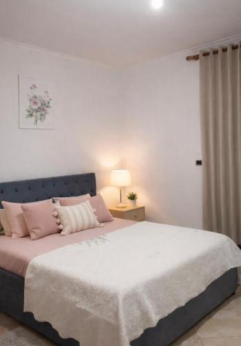 a bedroom with a large bed with pink pillows at Villa's Daci in Tirana