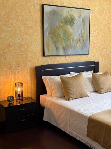 a bedroom with a bed and a painting on the wall at Casa Cataleia VILLA INN in Ponte de Lima