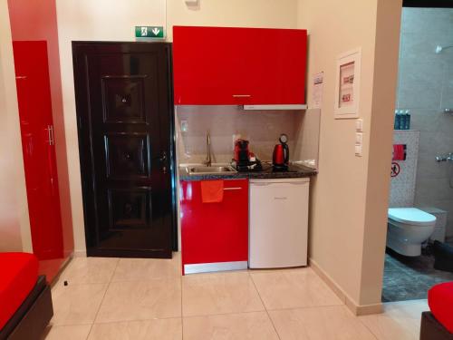 a small kitchen with red cabinets and a sink at Apartments Vesna Luxury ap 5 & 6 Paralia in Paralia Katerinis
