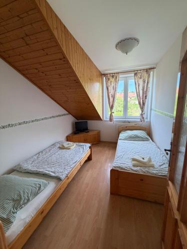 a bedroom with two beds and a window at Pizzerie Osičko in Bystřice pod Hostýnem