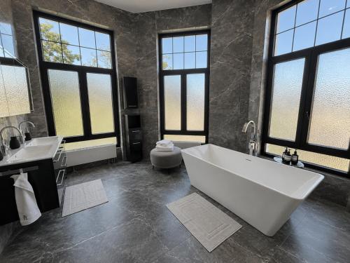 a large bathroom with a large tub and two sinks at White House Meerane - Loft Sky in Meerane
