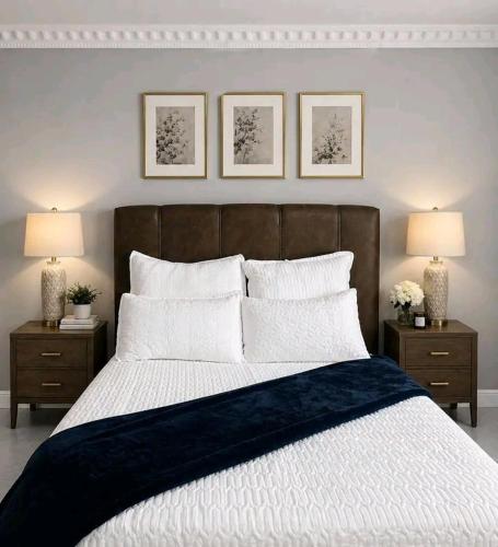 a bedroom with a large bed with two nightstands and two lamps at R&N Hosts in Maseru